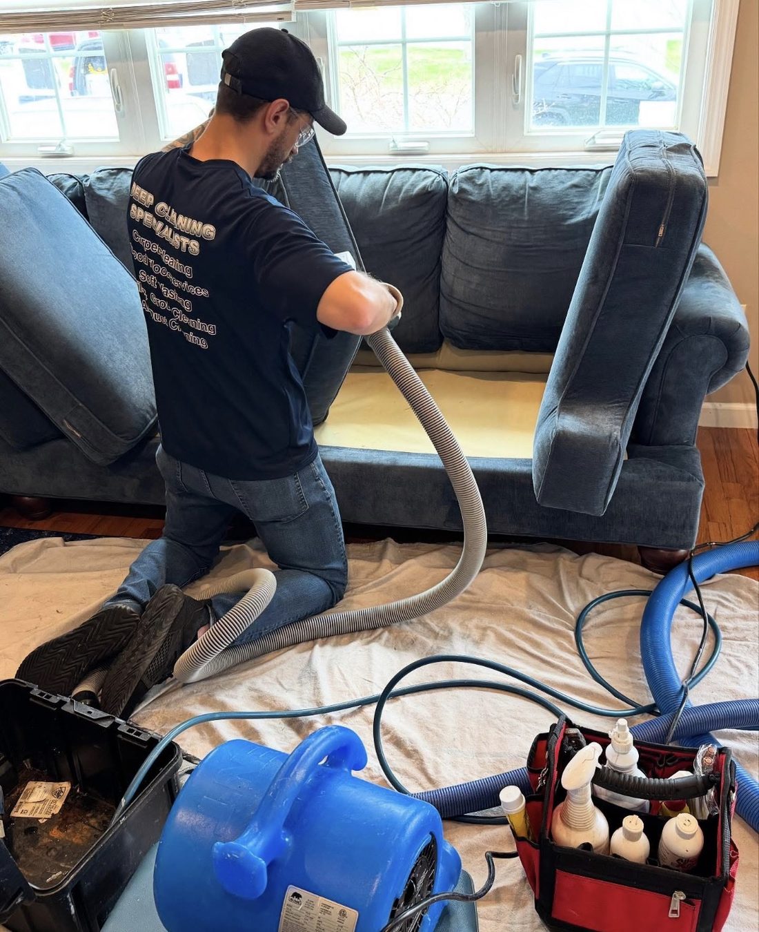 Technician steam cleaning a sofa